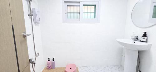 a white bathroom with a shower and a sink at MAMA Alice in Seoul