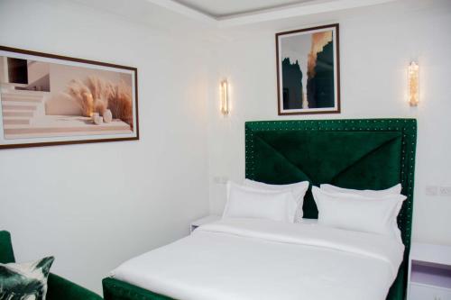 a bedroom with a bed with a green headboard at Shanny's Cozy Studio in Eldoret