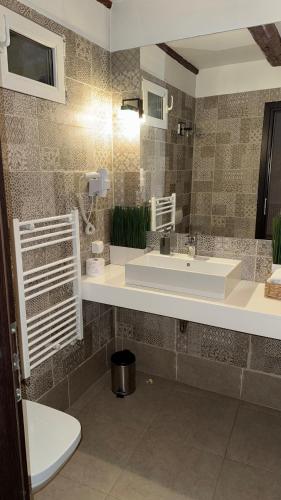 a bathroom with a sink and a toilet at Vendi Grand Square Residence in Sibiu