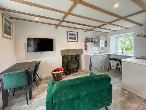 a living room with a table and a fireplace at Landberrick Farm Bothy 1 in Mochrum
