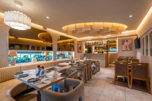 ein Restaurant mit Tischen und Stühlen und einer Bar in der Unterkunft Hotel Oriental Aster - Mumbai International Airport in Mumbai