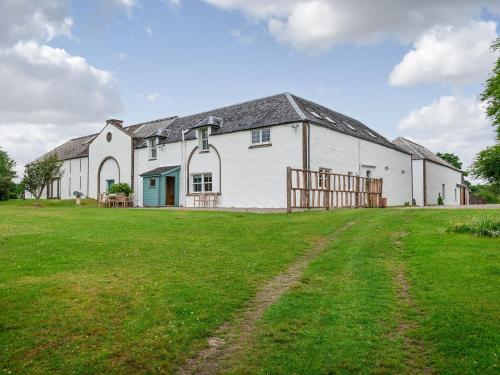 a large white building with a grass yard at Coachman's Bothy - Ukc5958 in Port Appin
