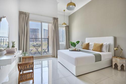 a white living room with a white couch and a window at Frank Porter - Canal Residence in Dubai