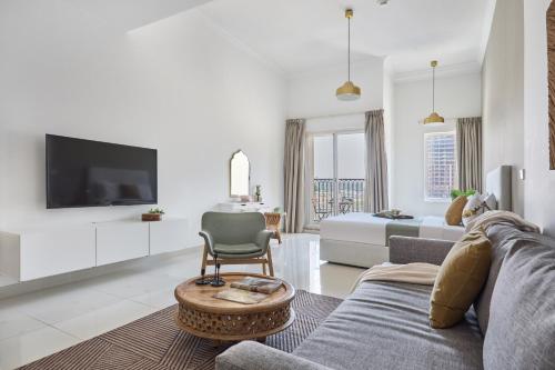 a living room with a couch and a tv at Frank Porter - Canal Residence in Dubai