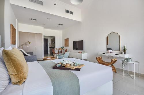 a bedroom with a white bed and a living room at Frank Porter - Canal Residence in Dubai