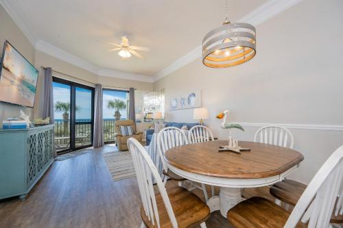 a dining room and living room with a table and chairs at Phoenix VI 6104 in Orange Beach