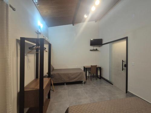 a room with a bed and a tv on the wall at Kitnet Vale do Amanhecer - Templo Mãe in Planaltina