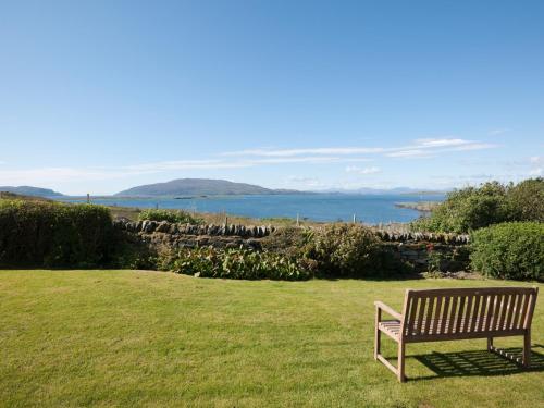a bench sitting in the grass in a field at Aird House in Ardfern