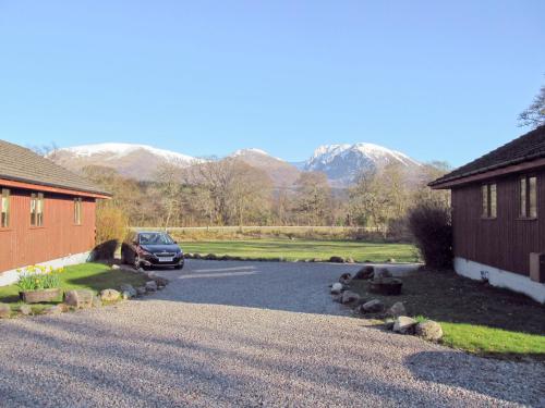 a car parked in a driveway with mountains in the background at Birch Lodge - 28880 in Torcastle