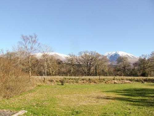 a field with snow covered mountains in the background at Birch Lodge - 28880 in Torcastle