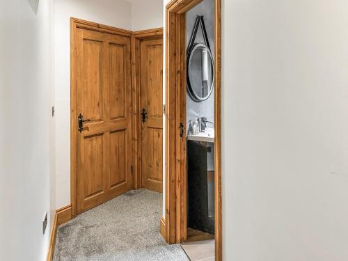 a hallway with a wooden door and a sink at The Curious Stag in Rothbury