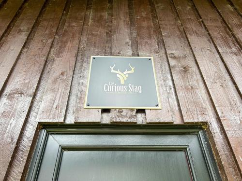 a sign over the door of a building at The Curious Stag in Rothbury