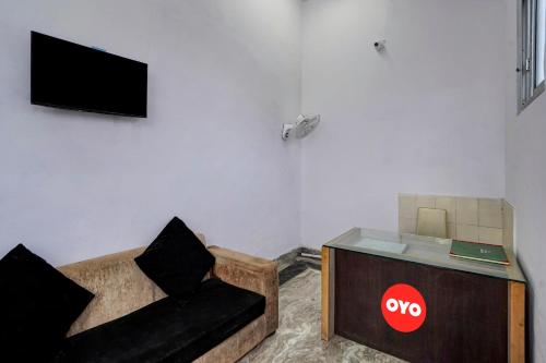 a living room with a couch and a tv at Hotel O Rest & Zone Hotel in Greater Noida