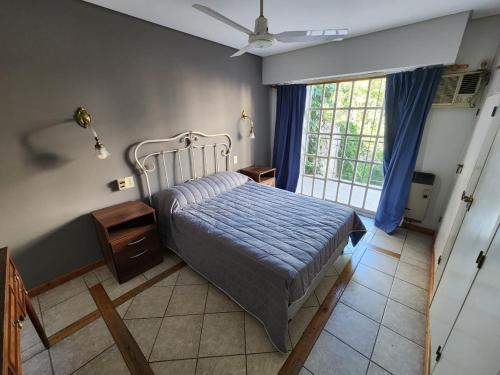 a bedroom with a bed and a large window at Departamento Microcentro San Rafael in San Rafael