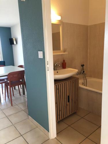a bathroom with a sink and a tub and a table at Studio vue mer in Cervione