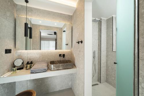 two images of a bathroom with a shower and a sink at Ethos Zeen Private Pool Suites in Potamiá