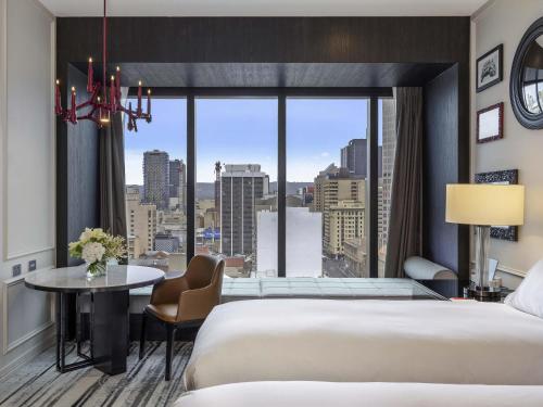 a hotel room with two beds and a large window at Sofitel Adelaide in Adelaide