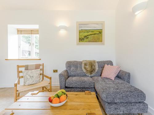 a living room with a couch and a bowl of fruit at Linnet - Uk50154 in Faversham