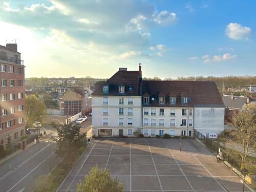 a large white building in a city with a parking lot at Le petit Versailles in Versailles