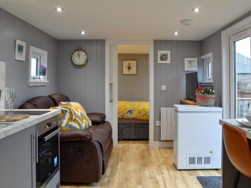 a kitchen with a couch and a living room at The Shepherd's Hut in Montrose