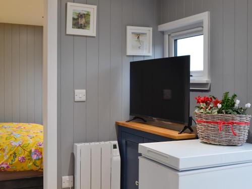 a living room with a tv on a dresser with a television at The Shepherd's Hut in Montrose