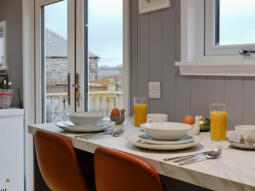 a table with plates and utensils on top of it at The Shepherd's Hut in Montrose