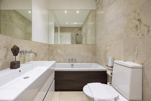a bathroom with a tub and a toilet and a sink at Exceptional 2 Bed Flat near Dulwich Park in London