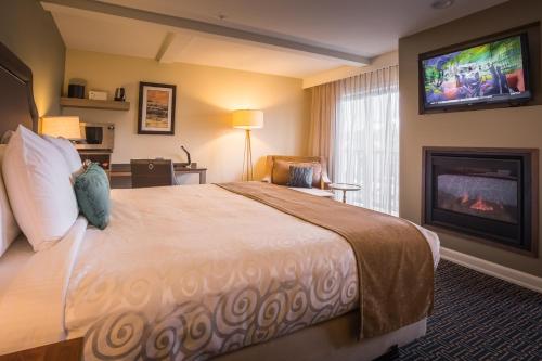 a hotel room with a large bed and a fireplace at Inn at Nye Beach in Newport