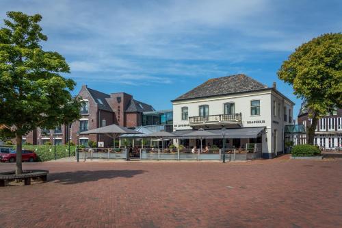 a building with a cafe in the middle of a street at Hotel De Lindeboom in Den Burg