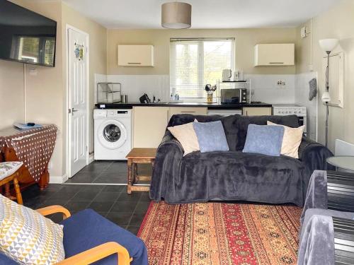 a living room with a couch and a kitchen at Beachside in Llanstephan