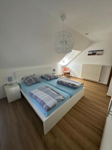 a bedroom with a large bed with blue sheets at Ferienhaus Talblick in Kelberg