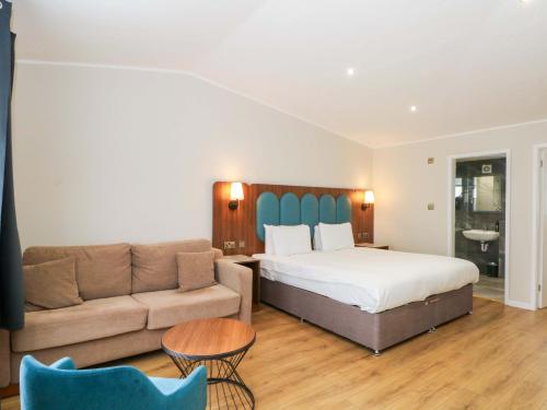 a hotel room with a bed and a couch at Hedgehog Lodge in Chorley