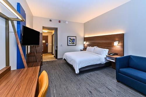 a hotel room with a bed and a blue couch at Holiday Inn Express Jasper by IHG in Jasper