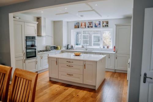 a kitchen with white cabinets and a white counter top at Charming St Davids Cottage with Cathedral Views in St. Davids