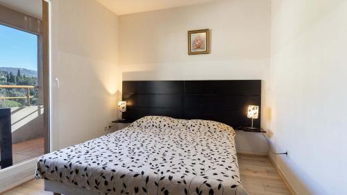 a bedroom with a bed and a large window at Virginia N 202 2P4 in Grasse