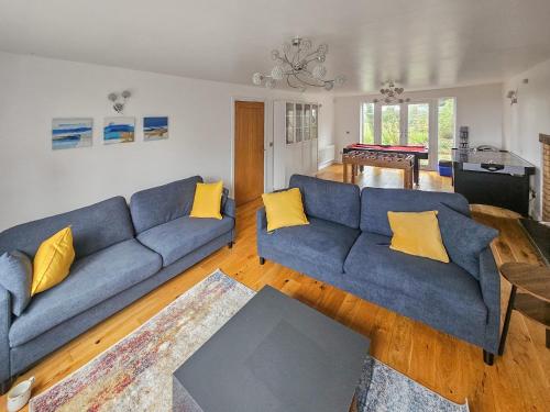 a living room with a blue couch and yellow pillows at Riverside in Wimblington