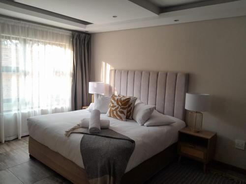 a bedroom with a bed with two lamps and a window at Magnolia Hotel in Middelburg