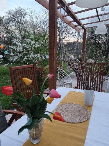 a table with a vase of tulips on a patio at Porta in Bálványos