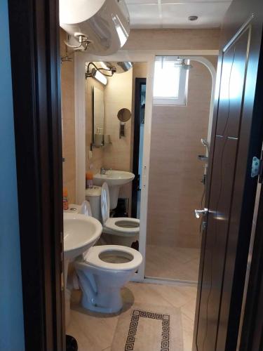 a bathroom with a toilet and a sink and a shower at Апартамент Лана 2 in Byala