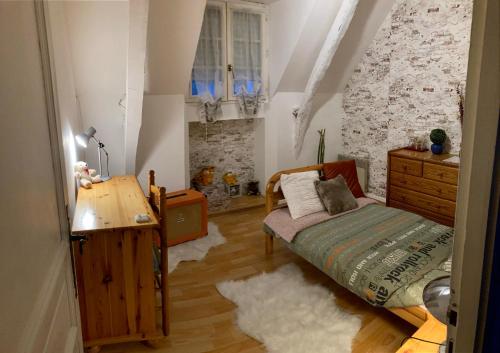 a bedroom with a bed and a dresser and a desk at Près de l'aéroport in Ossun