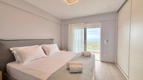 a bedroom with a large bed and a large window at Villa Palomar in Kyparissia