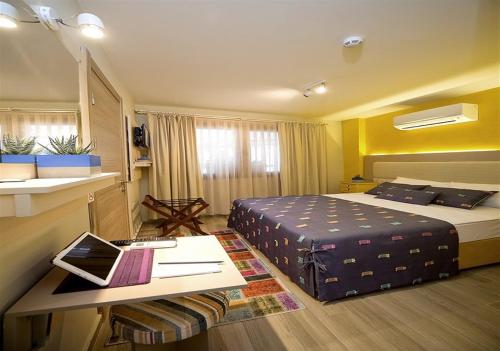 ein Hotelzimmer mit Bett und Schreibtisch mit Laptop in der Unterkunft Dions hotel in Seferihisar