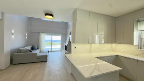 a large white kitchen with a couch and a living room at Villa Palomar in Kyparissia
