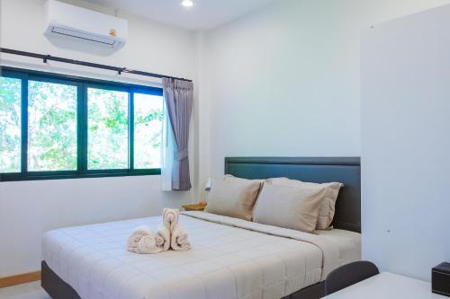 a bedroom with a bed with two towels on it at Chaba Pool Villa Khao Lak in Khao Lak