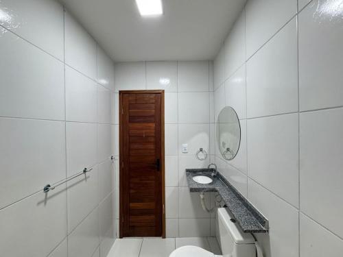 a bathroom with a toilet and a sink and a mirror at Casa em Tibau in Tibau