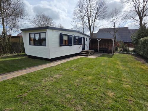a small white tiny house in a yard at De Greidefûgel in Westergeest