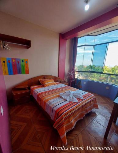 a bedroom with a bed and a large window at Alojamiento Morales Beach in Morales