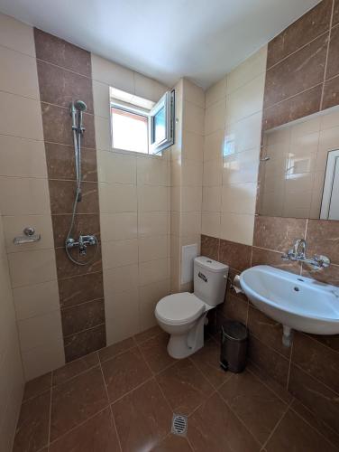 a bathroom with a toilet and a sink and a shower at Hotel Poli in Blagoevgrad