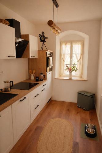 a kitchen with white cabinets and a window at Gutshof 1600 in Hohnstein