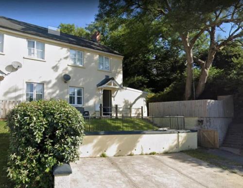 a white house with a fence in front of it at 55 Incline Way - Saundersfoot Coastal Retreat with Patio & Parking in Pembrokeshire